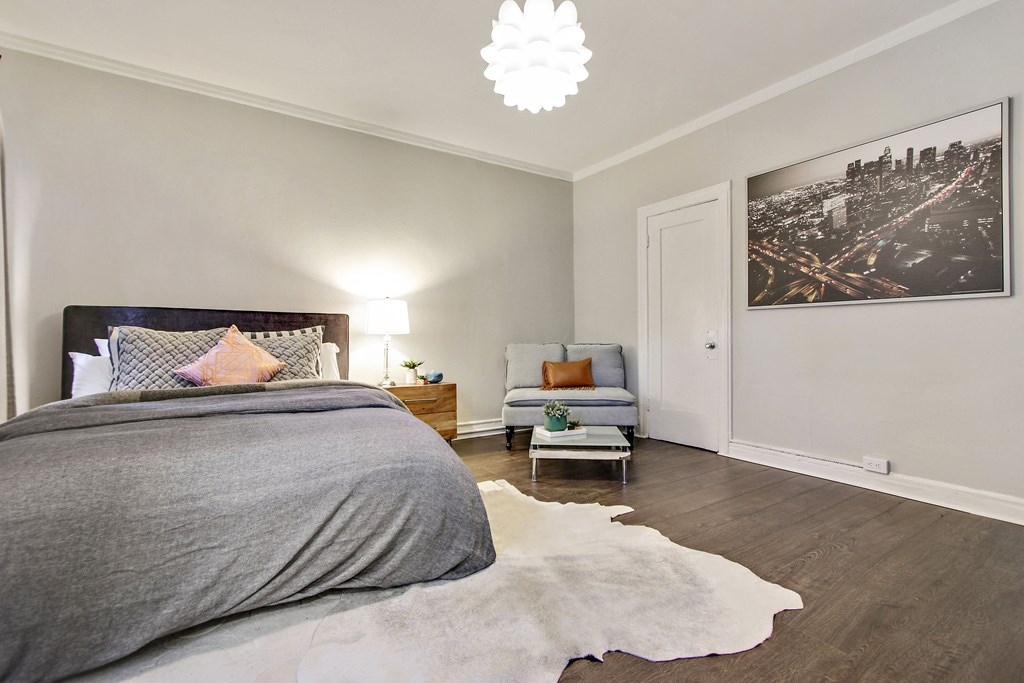 A bedroom with a large bed and a cowhide rug.