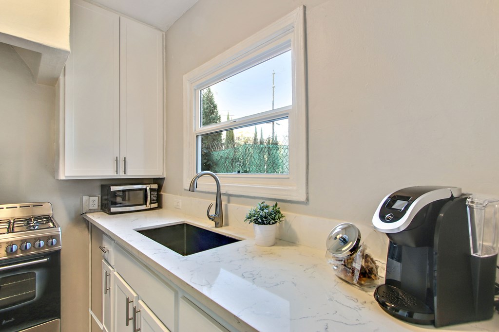 A kitchen with a black coffee maker on the counter.