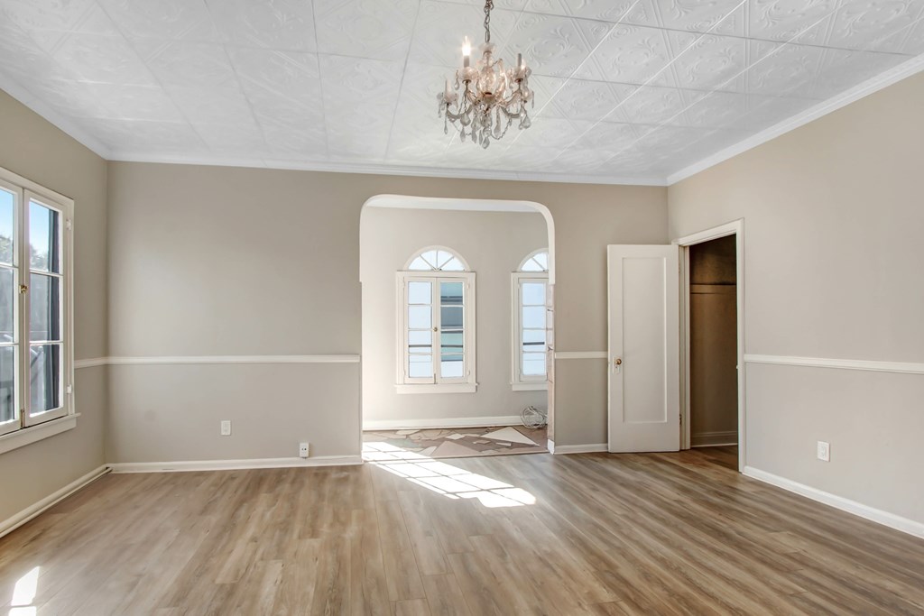 A room with wooden floors and a chandelier.