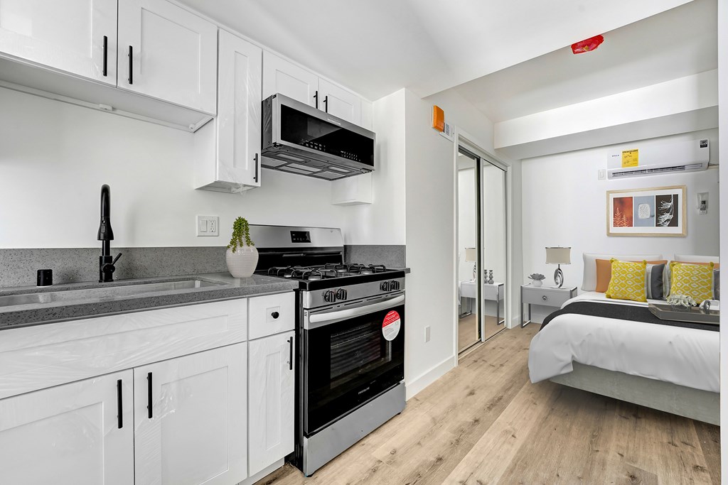A modern kitchen with white cabinets and a stainless steel oven.
