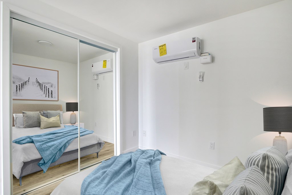 A bedroom with a bed covered in a blue blanket.