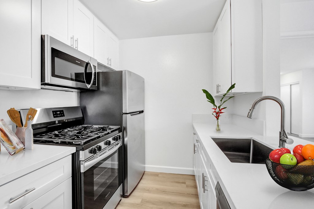 A modern kitchen with a stainless steel refrigerator, oven, and microwave.