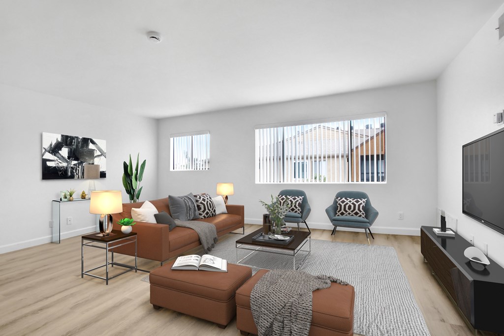 A living room with a brown couch, a grey couch, a coffee table, and a television.