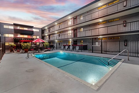 A swimming pool in a courtyard surrounded by apartment buildings.