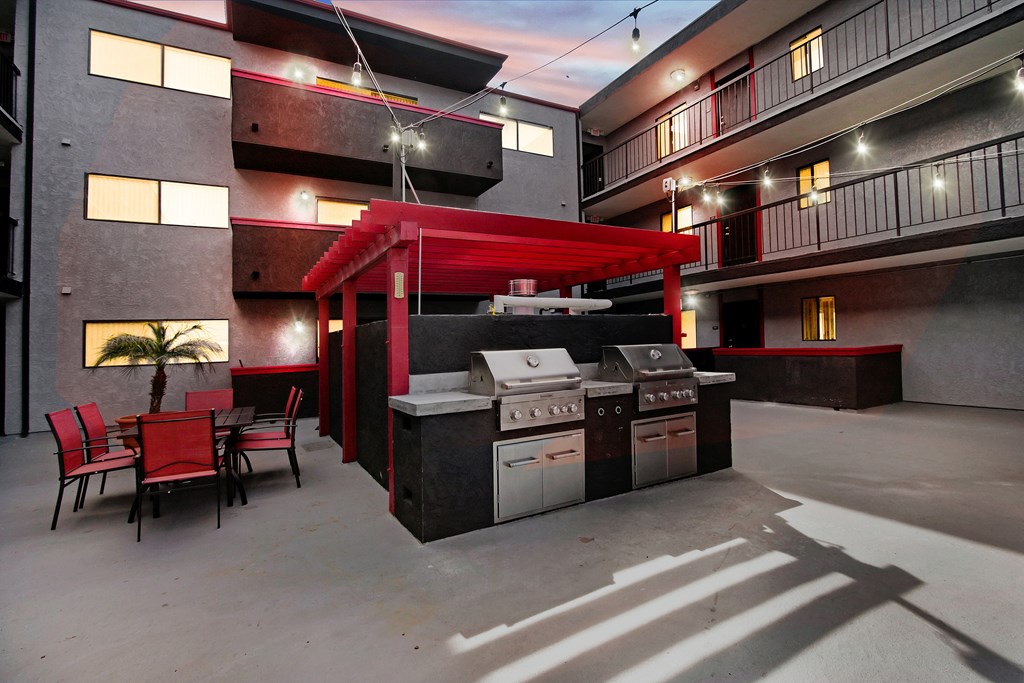 A modern outdoor kitchen area with a grill and seating area.