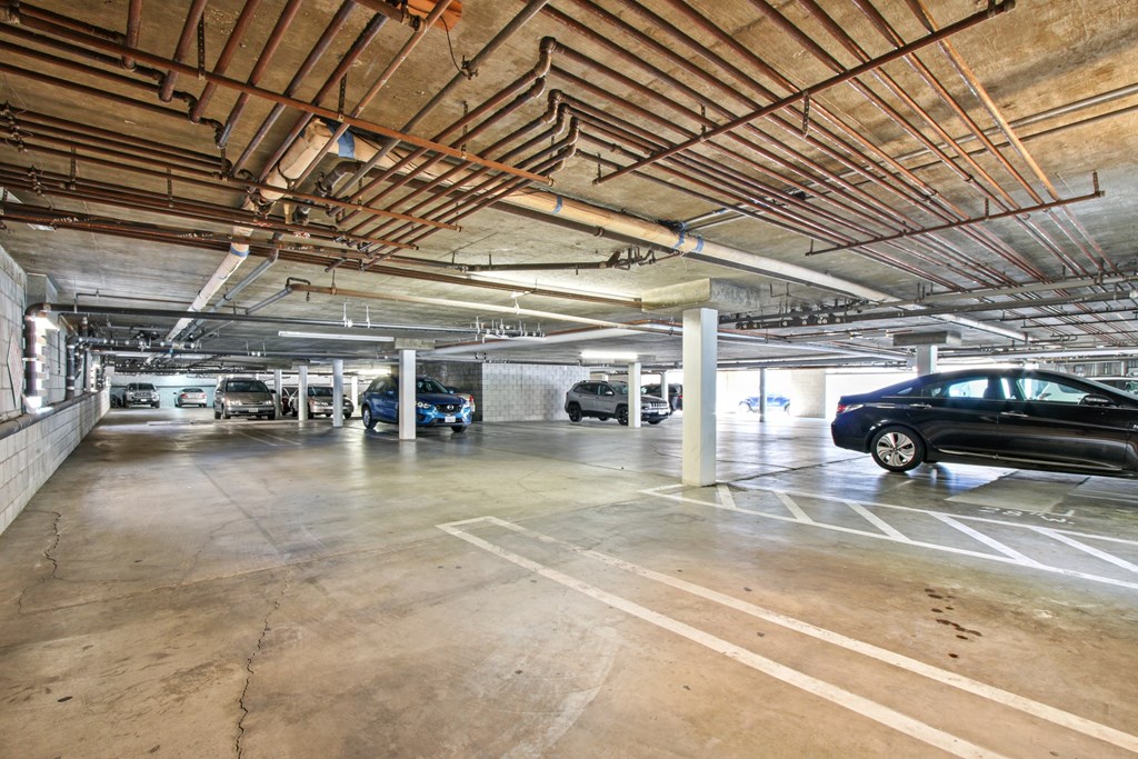 A parking garage with several cars parked.