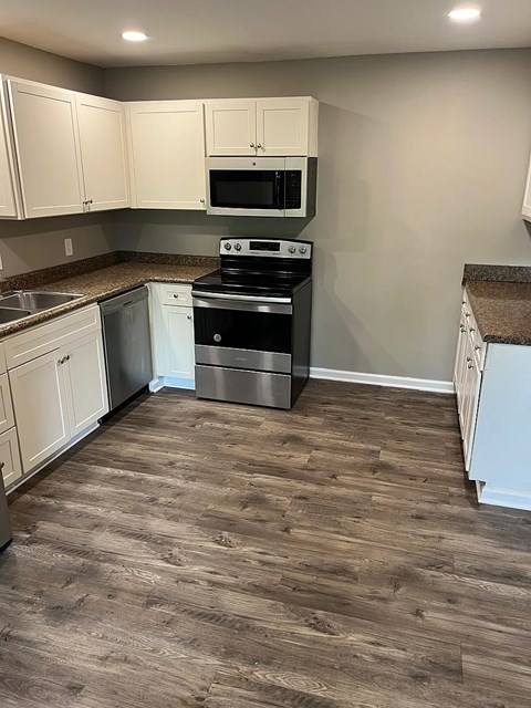 A kitchen with a stove top oven and microwave.