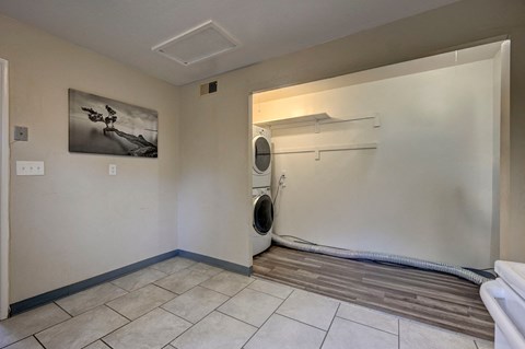 A room with a washing machine and a painting on the wall.