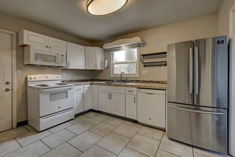 A kitchen with white appliances and cabinets.