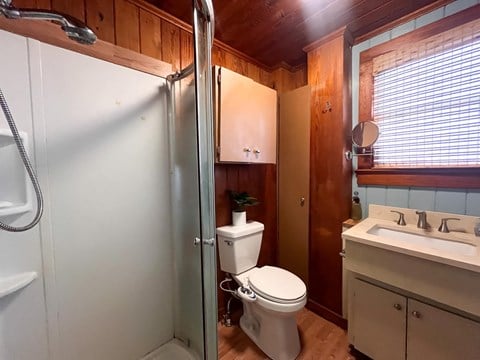 A bathroom with a toilet, sink, and shower.