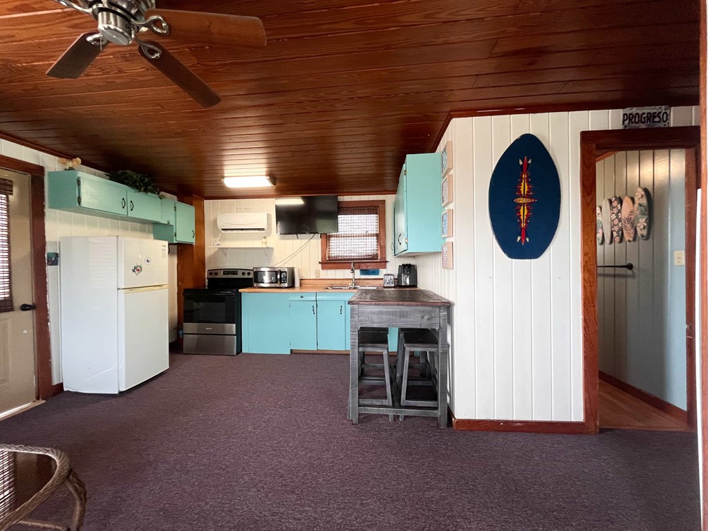 A kitchen with a ceiling fan and a blue oval sign on the wall.