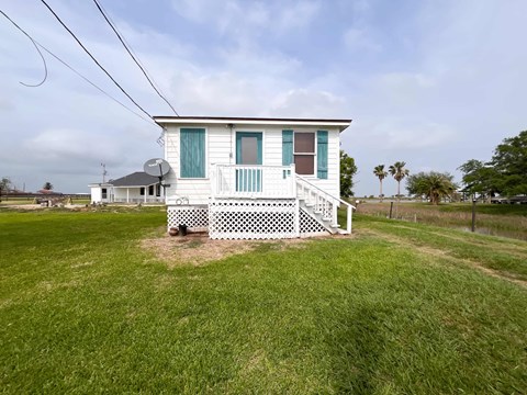 A white house with a green door and a porch.