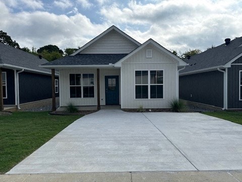 A white house with a grey roof and a grey garage door.