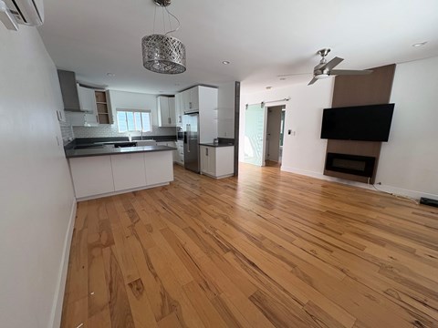A kitchen with wooden floors and white walls.