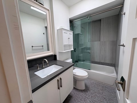 A bathroom with a white toilet, sink, and bathtub.