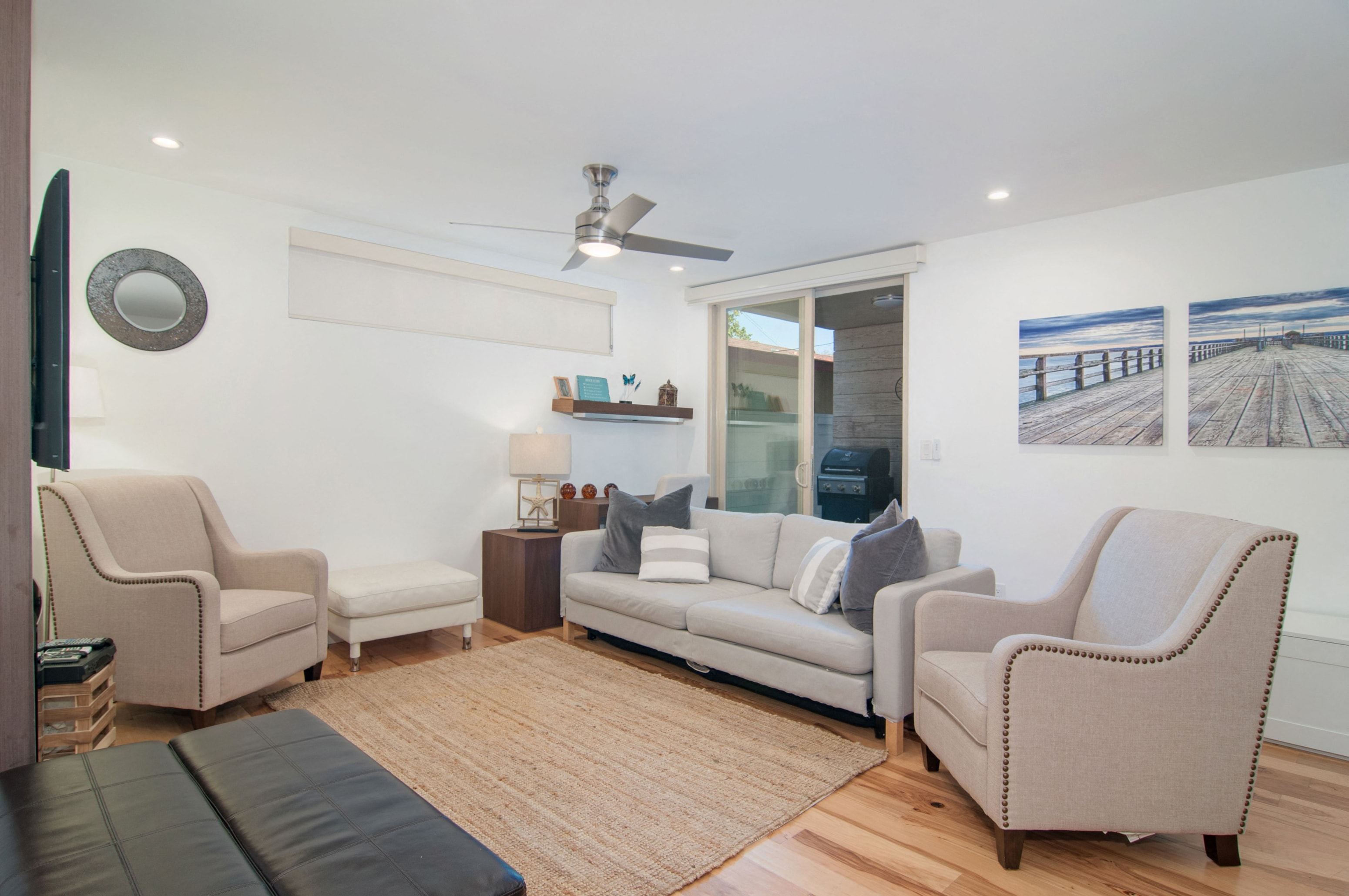 A living room with a couch, chairs, and a television.