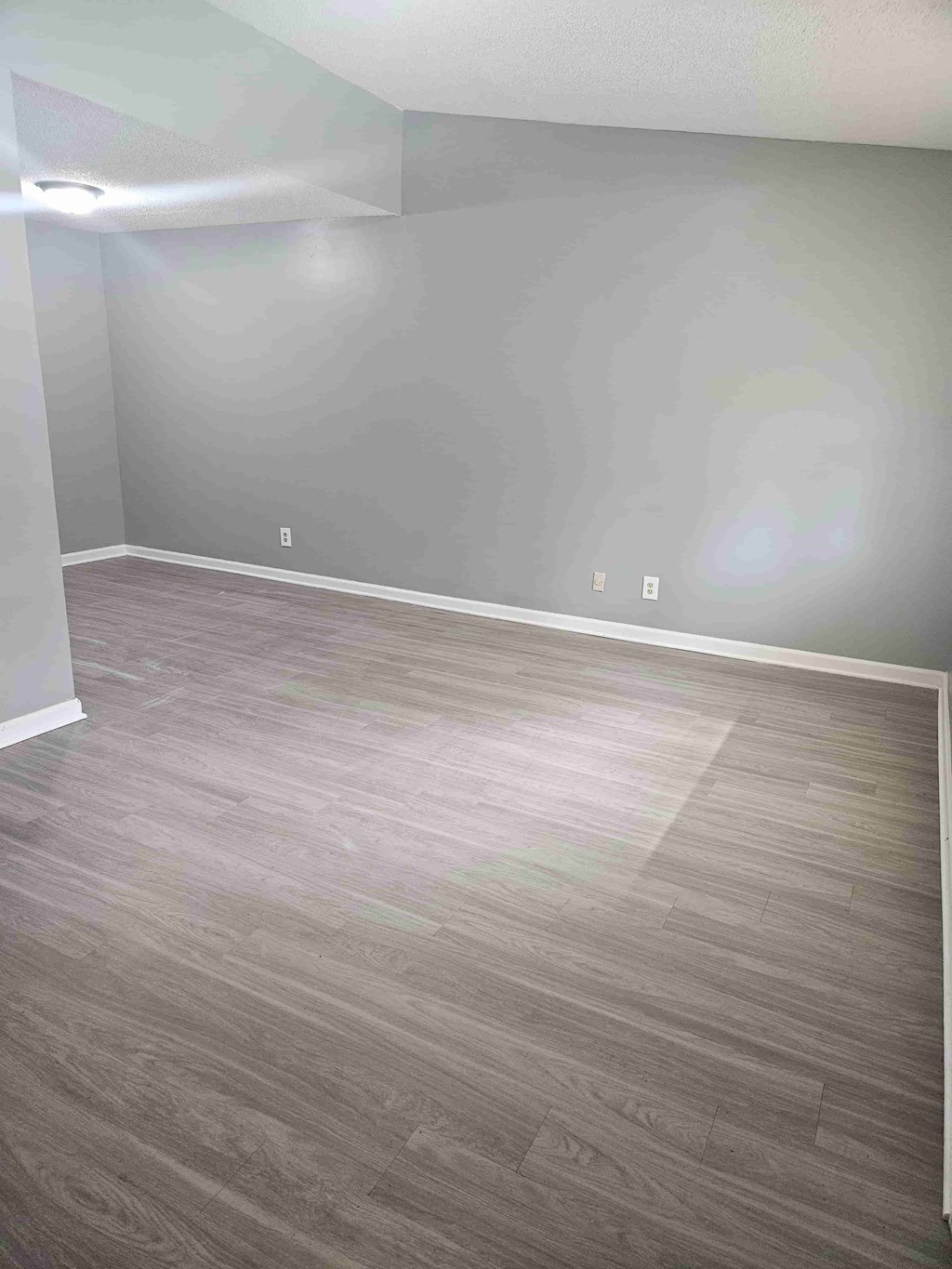 A room with a grey floor and a grey wall.