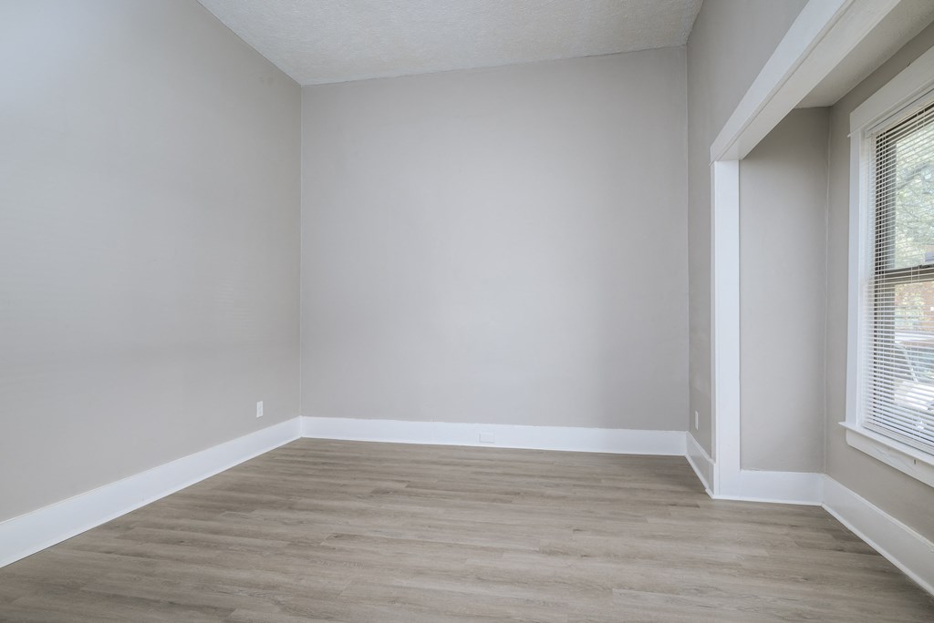 A room with a window and wooden flooring.