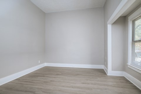 A room with a window and wooden flooring.