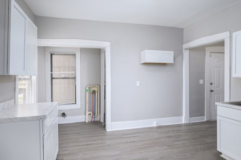 A white kitchen with a window and a door.