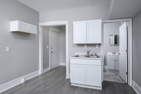 A white kitchen with a sink and cabinets.