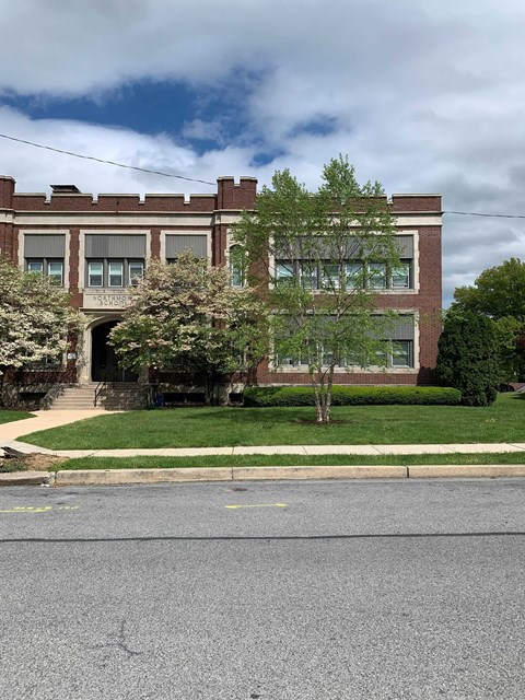 A brick building with a tree in front of it.