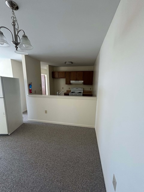 A kitchen area with a fridge, dishwasher, and a window.