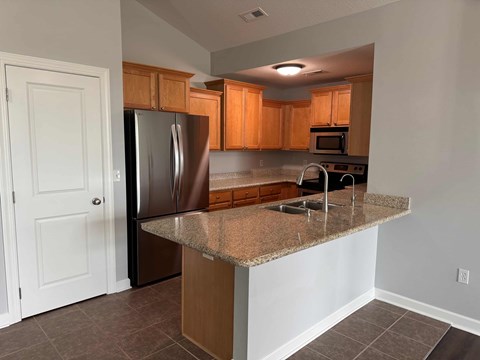 A kitchen with a granite countertop and stainless steel appliances.
