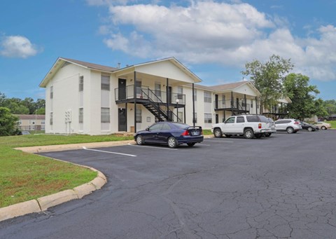 A parking lot with cars and apartment buildings in the background.