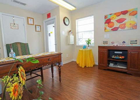 A room with a wooden table and a yellow skirt.