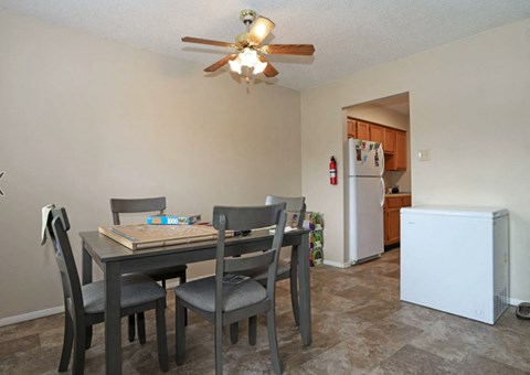 A dining room with a table and chairs.
