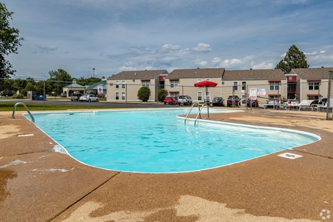A large swimming pool with a diving board in the middle of it.