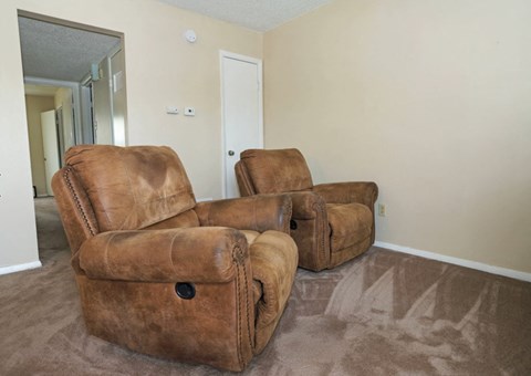 Two brown leather chairs in a room.