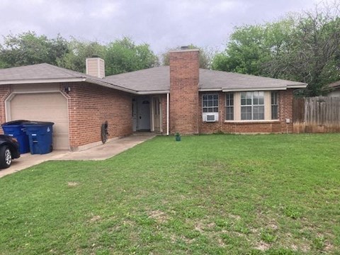 A house with a brown brick exterior and a grey roof.