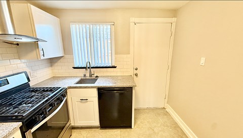 A room with wooden flooring and a window with blinds.