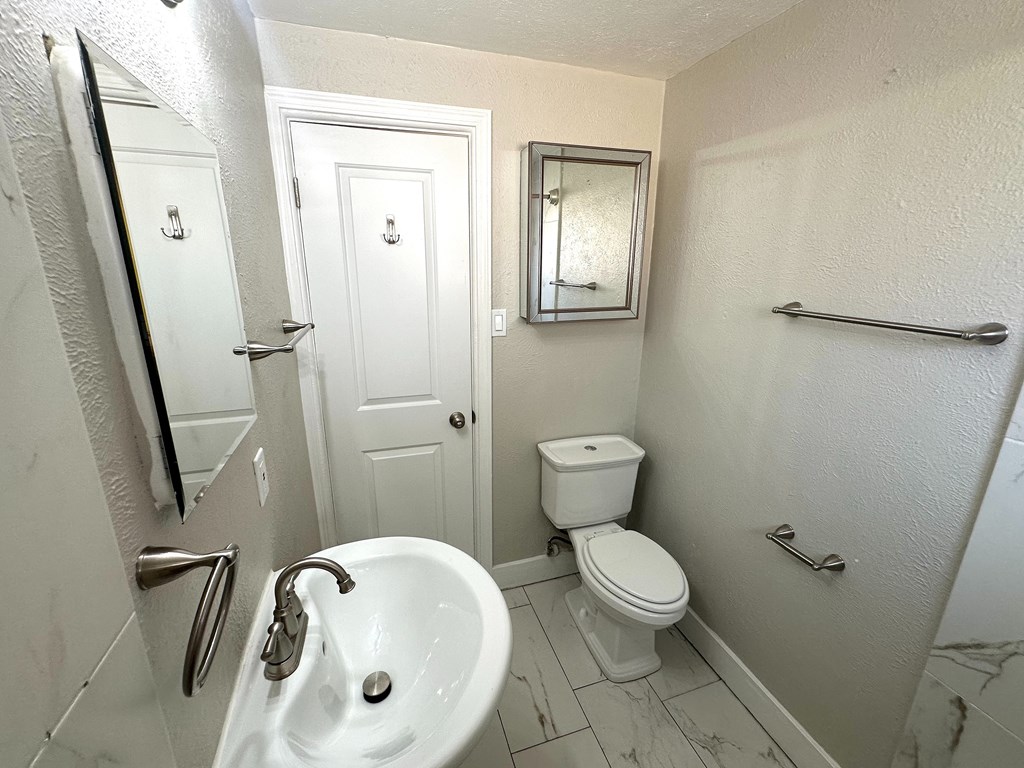 A white toilet sits next to a sink in a bathroom.