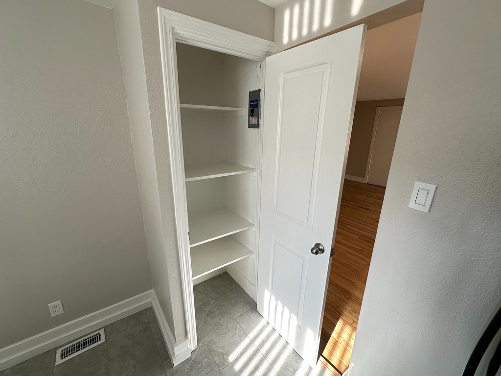 A white door with a shelf underneath it.