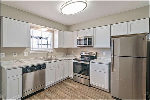 A kitchen with white cabinets and stainless steel appliances.