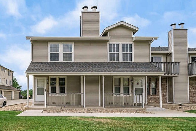 A house with a grey roof and a white car parked in front.