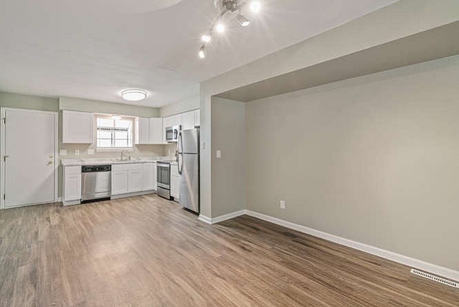 A kitchen with white cabinets and a window.