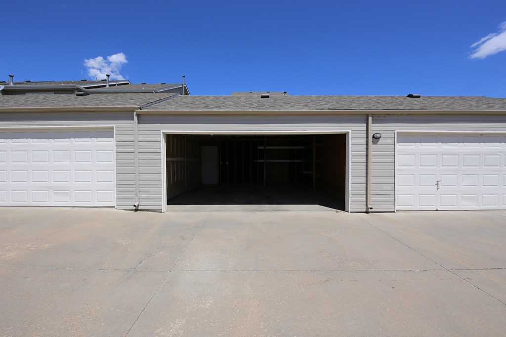 A garage door is open and the garage is empty.