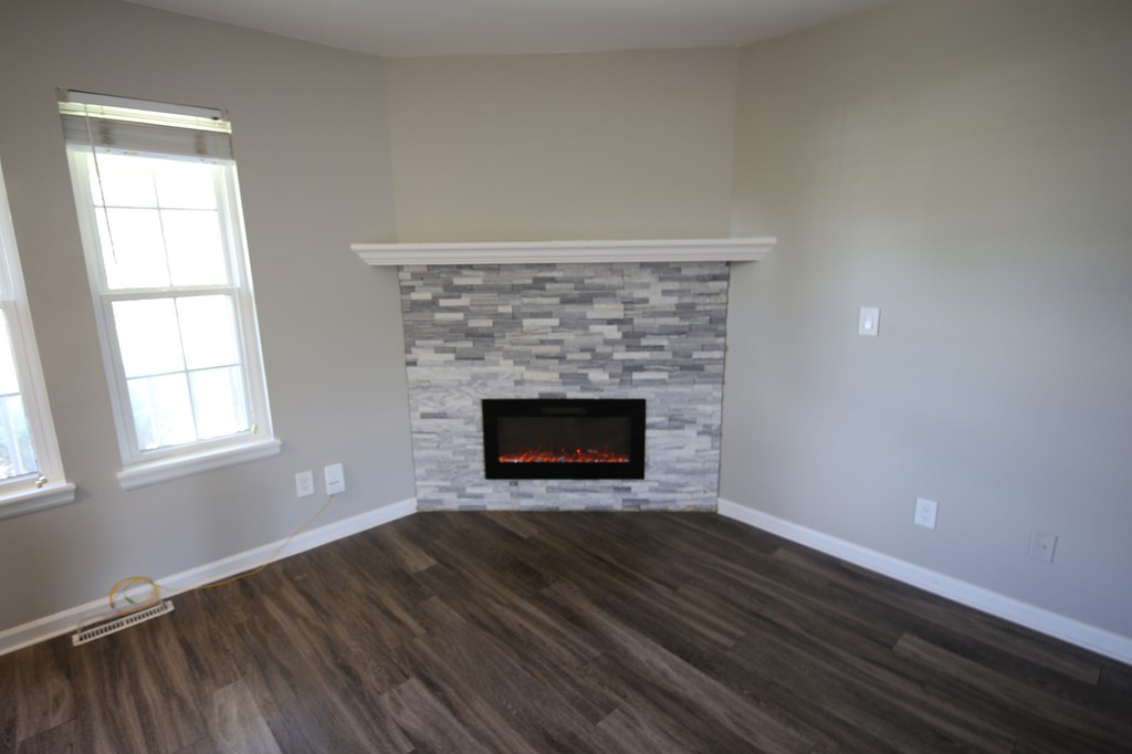 A room with a fireplace and wooden floors.