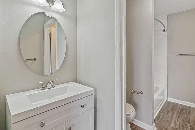 A bathroom with a sink, mirror, and toilet.