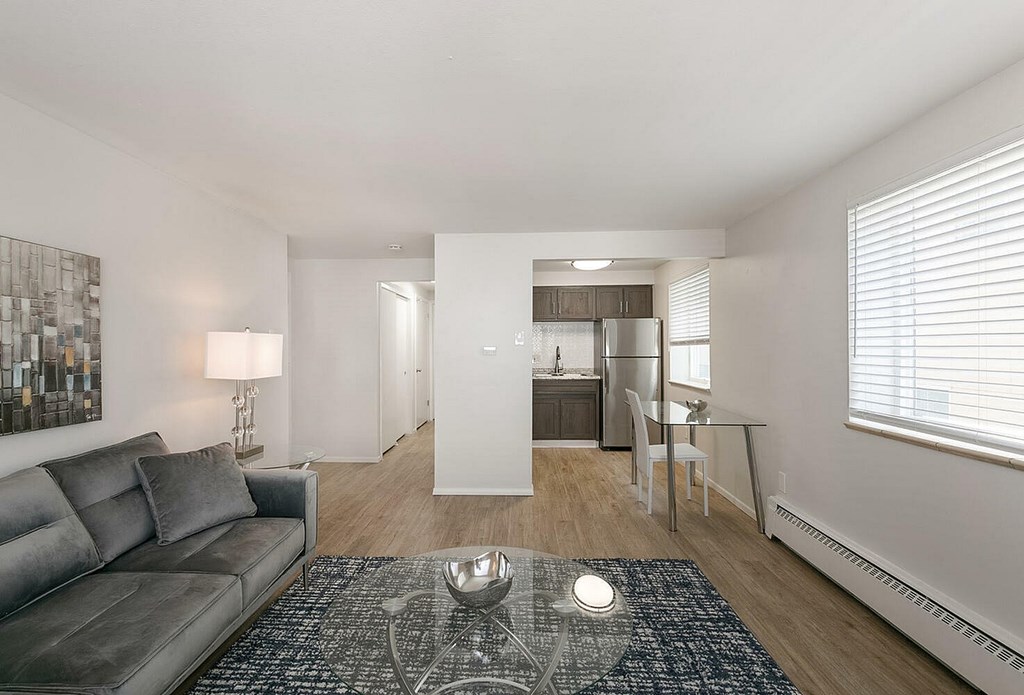 A modern two-story building with a black awning and a red brick pathway leading to the entrance.