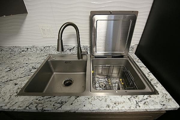 A kitchen sink with a faucet and a dish drainer.