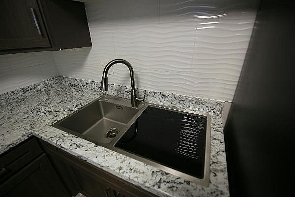 A kitchen sink with a faucet and a countertop.