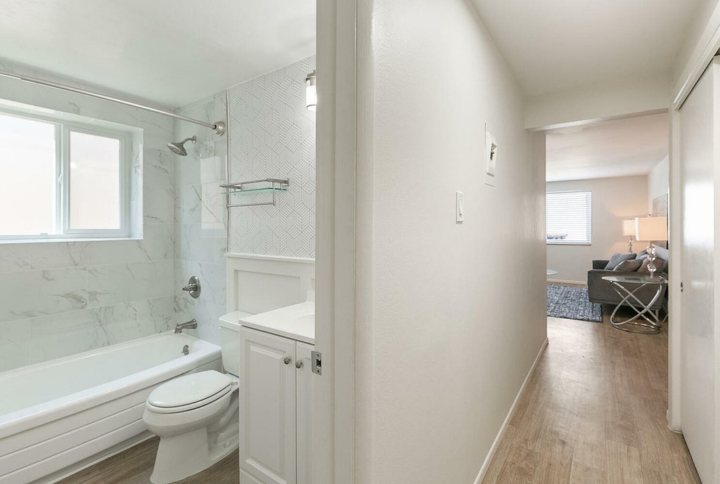A white bathroom with a tub, toilet, and sink.