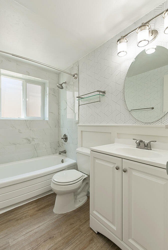 A white bathroom with a toilet, sink, and tub.
