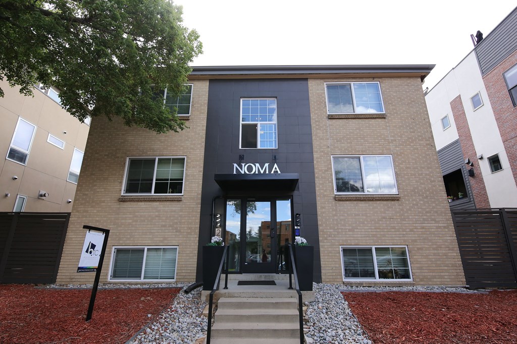 A building with a black awning and a glass door with a number 27 on it.
