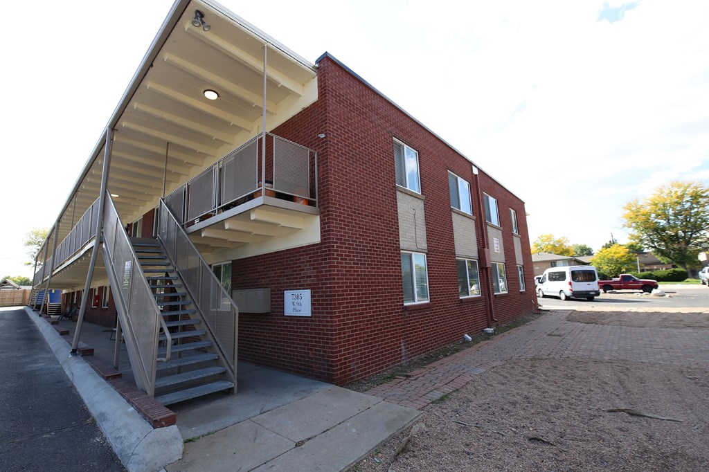 A red brick building with a metal staircase outside.